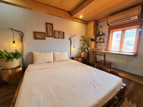 a bedroom with a large white bed in a room at TỊNH Retreat Phu Quoc in Phu Quoc