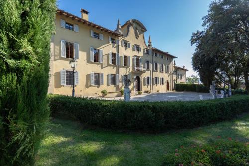 a large yellow building with a hedge in front of it at Il Marchese Di Ronta in Ronta