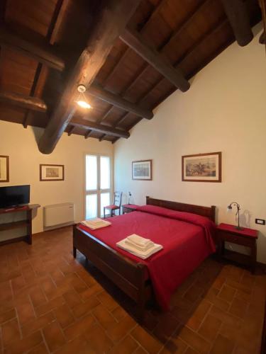 a bedroom with a large bed with red sheets at Agriturismo La Bisa in Trecenta