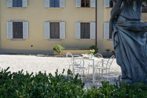 a table with chairs and a statue in front of a building at Il Marchese Di Ronta in Ronta
