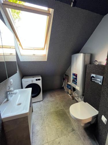 a bathroom with a sink and a toilet and a window at Butas Pagėgiuose in Pagėgiai