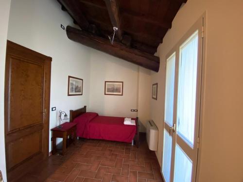 a bedroom with a red bed in a room at Agriturismo La Bisa in Trecenta
