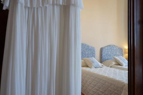 a bedroom with a bed and two blue chairs at Il Marchese Di Ronta in Ronta
