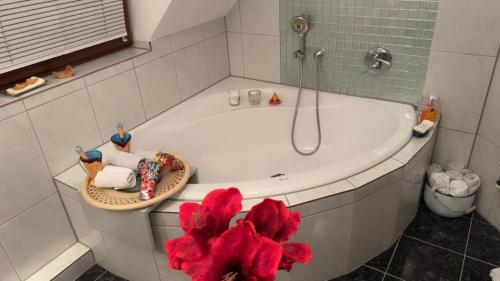 a bathroom with a bath tub with a red flower at Gabriel in Sankt Augustin