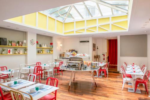a dining room with tables and chairs and a skylight at Hotel Astoria - Astotel in Paris