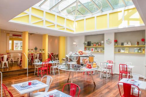 a restaurant with tables and chairs and a skylight at Hotel Astoria - Astotel in Paris