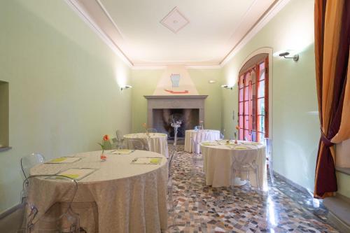 a room with tables with white table cloths and a fireplace at Il Marchese Di Ronta in Ronta