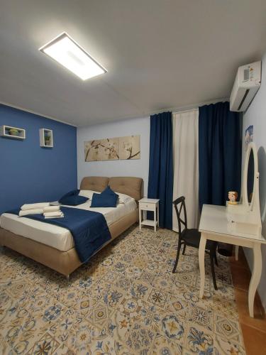 a bedroom with a bed and a table and a desk at B&B Piazza Mazzini in Catania