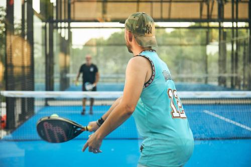 a man holding a tennis racket on a tennis court at Setclub Hôtel & Spa Aix-en-Provence in Aix-en-Provence