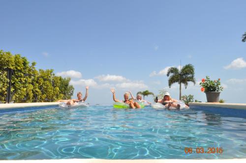 a group of people floating in a swimming pool at Hawk's Nest Bed & Breakfast in La Laguna de San Carlos