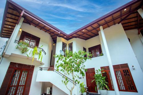 a white house with red doors and windows at Su Yu villa in Unawatuna