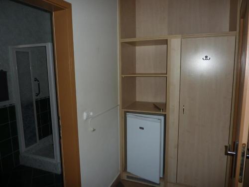 a room with a closet with a door and a shelf at Party Panzió Hegykő in Hegykő