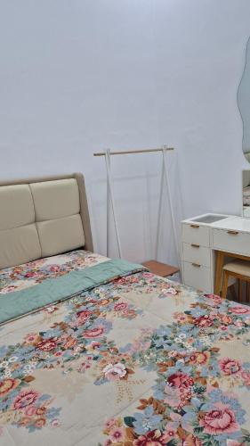 a bedroom with a bed with a floral blanket on it at adinda syariah H-1 Villa Anggrek Jl Proklamasi in Garut