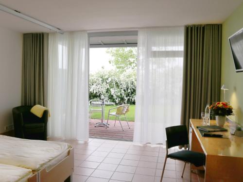LobbachにあるSeminarhotel in der Manfred-Sauer-Stiftungのベッドと机と窓があるホテルの部屋