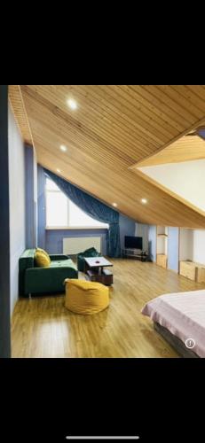 a living room with a green couch and a bed at Tbilisi Vera in Tbilisi City