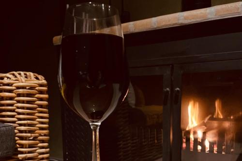 a glass of wine sitting in front of a fireplace at Skye Ridge in Calitzdorp