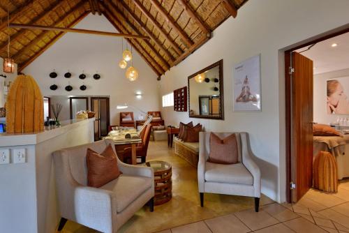 a living room with two chairs and a table at African Hills Safari Lodge & Spa in Magaliesburg