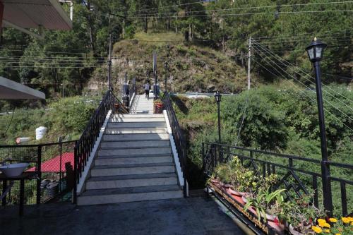 Una escalera que conduce a una colina con flores. en Swastik Inn, en Jāmb