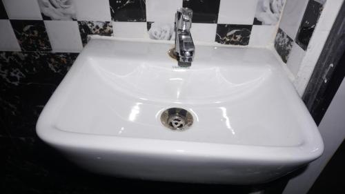 a white sink with a faucet in a bathroom at Shri Ashray in Varanasi