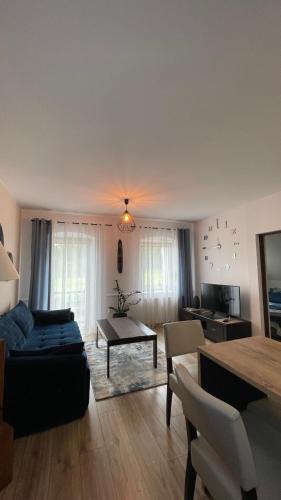 a living room with a couch and a table at Apartamenty Leśna Osiem in Jeżów Sudecki