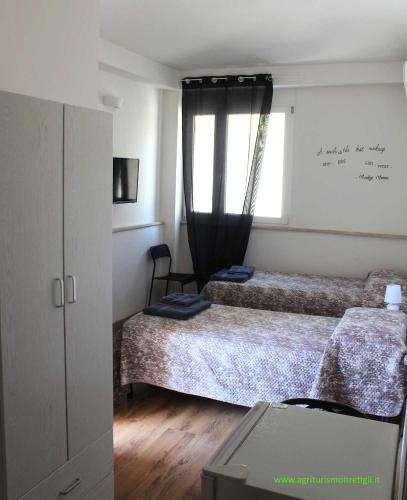 a bedroom with two beds and a window at Agriturismo I TRE TIGLI in Rignano Flaminio