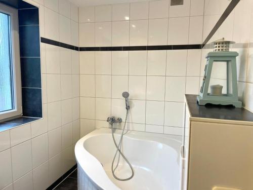 a bathroom with a bath tub with a shower at Ferienhaus "Hagen" in Schkopau in Schkopau