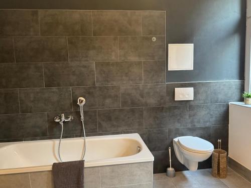 a bathroom with a bath tub and a toilet at Appartement "Hans" in Köthen mit 4 Schlafzimmern in Köthen