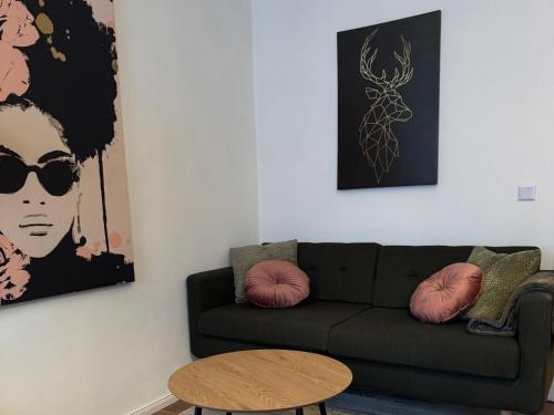 a living room with a black couch and a table at Appartement "Hans" in Köthen mit 4 Schlafzimmern in Köthen