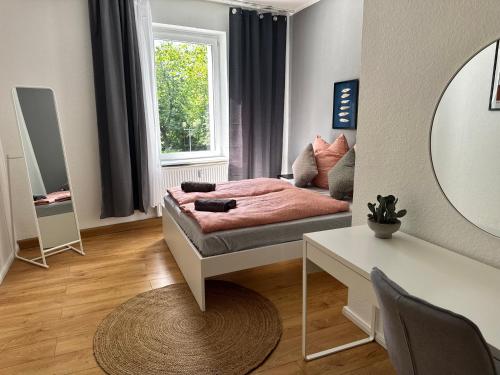 a bedroom with a bed and a table and a mirror at Appartement "Martha" mit 3 Schlafzimmern an Goitzsche Bitterfeld in Niederdorla