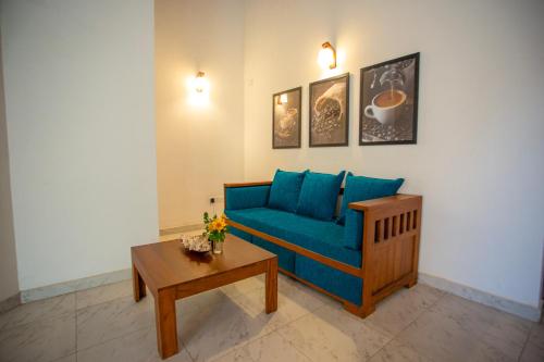 a living room with a blue couch and a table at Su Yu villa in Unawatuna