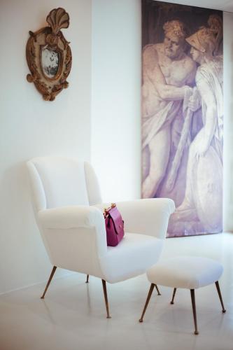 a white chair in a room with a painting at Hotel Villa Taormina in Taormina