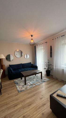 a living room with a blue couch and a table at Apartamenty Leśna Osiem in Jeżów Sudecki