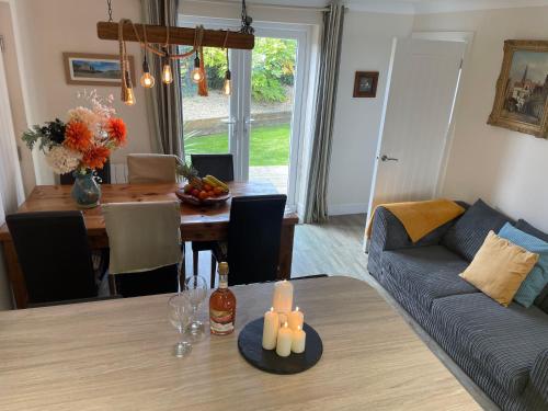 a living room and dining room with a table and a couch at 2 Fernleigh Villas in Perranporth