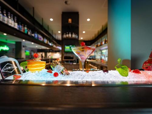 a bar with a martini glass sitting on top of snow at ibis Styles Hamburg Barmbek in Hamburg