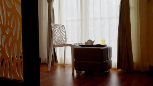 a table and a chair in front of a window at Yeasel Continental By Staynest in Gangtok