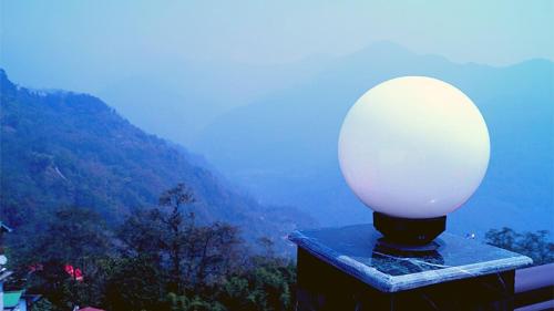 a lamp sitting on a table with a view of a mountain at Yeasel Continental By Staynest in Gangtok