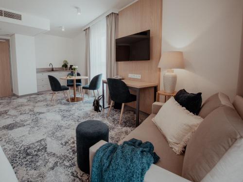 a living room with a couch and a table at Arche Hotel Lotnisko Gdańsk in Firoga