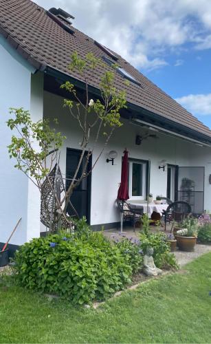 a white house with a table and a chair at Haus Sengbach in Heide