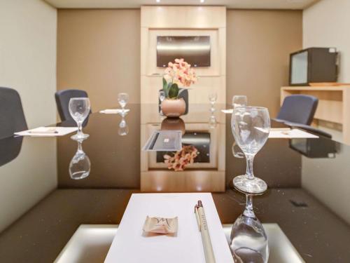 a dining room with wine glasses on a table at Mercure Rio de Janeiro Barra da Tijuca in Rio de Janeiro