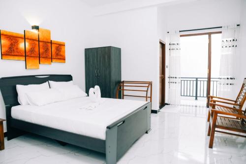 Un dormitorio con una cama grande y una silla. en Villa 64, en Negombo