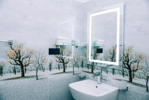 Un baño con espejo y lavabo y árboles. en Villa 64, en Negombo