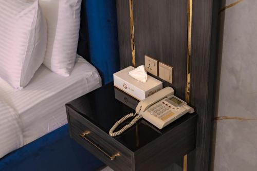 a telephone sitting on a table next to a bed at Palazzo hotel in Kuwait