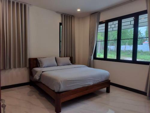a bedroom with a bed and a large window at BAAN PAHK JAI by Dragon hut in Hinkong