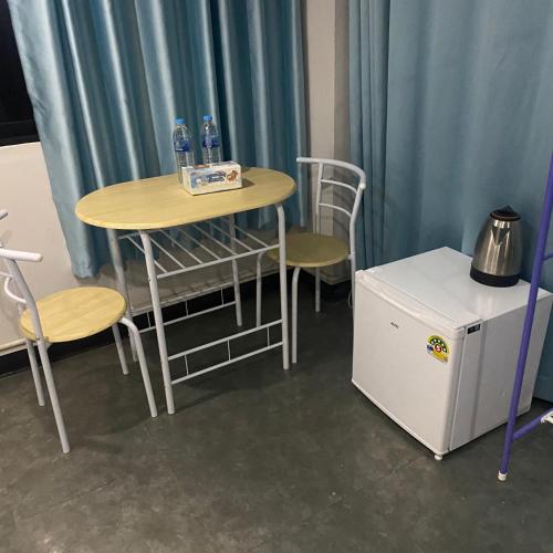 a small table and chairs and a small refrigerator at Saran Hotel krabi Thailand in Krabi