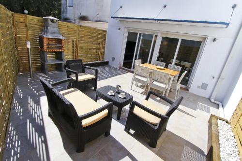 a patio with chairs and tables and a stove at NATURE PLUS Family House in Salou