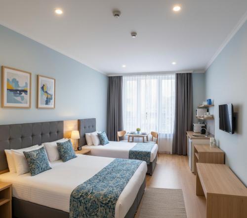 a hotel room with two beds and a television at Arsuz Paart Otel in Arsuz