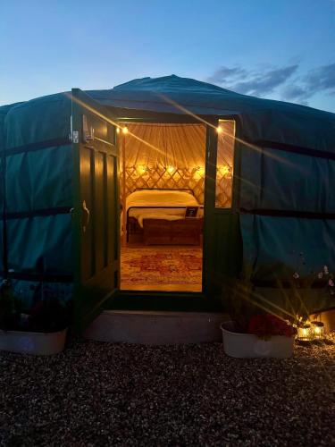 a green tent with a bed inside of it at The Skye Yurt in Messing
