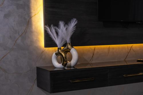 two vases with feathers in them sitting on a dresser at Palazzo hotel in Kuwait