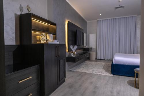a hotel room with a bed and a dresser at Palazzo hotel in Kuwait