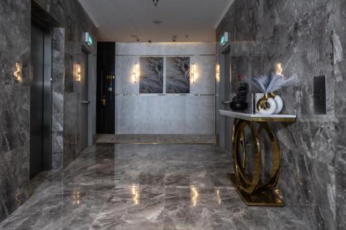 a lobby with a marble wall and a table at Palazzo hotel in Kuwait